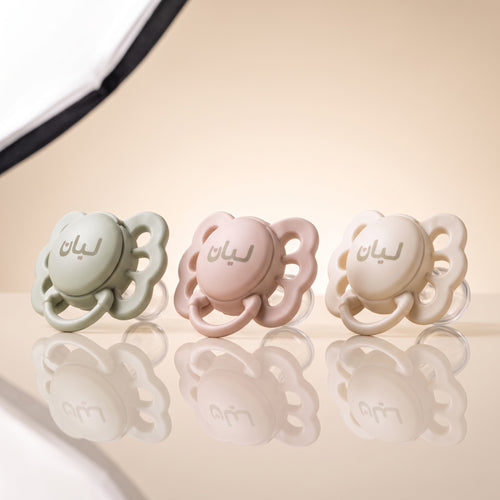 Les trois tétines LIYAN alignées : vert sauge, rose poudré et crème