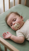 Bébé endormi dans son lit avec une tétine LIYAN crème